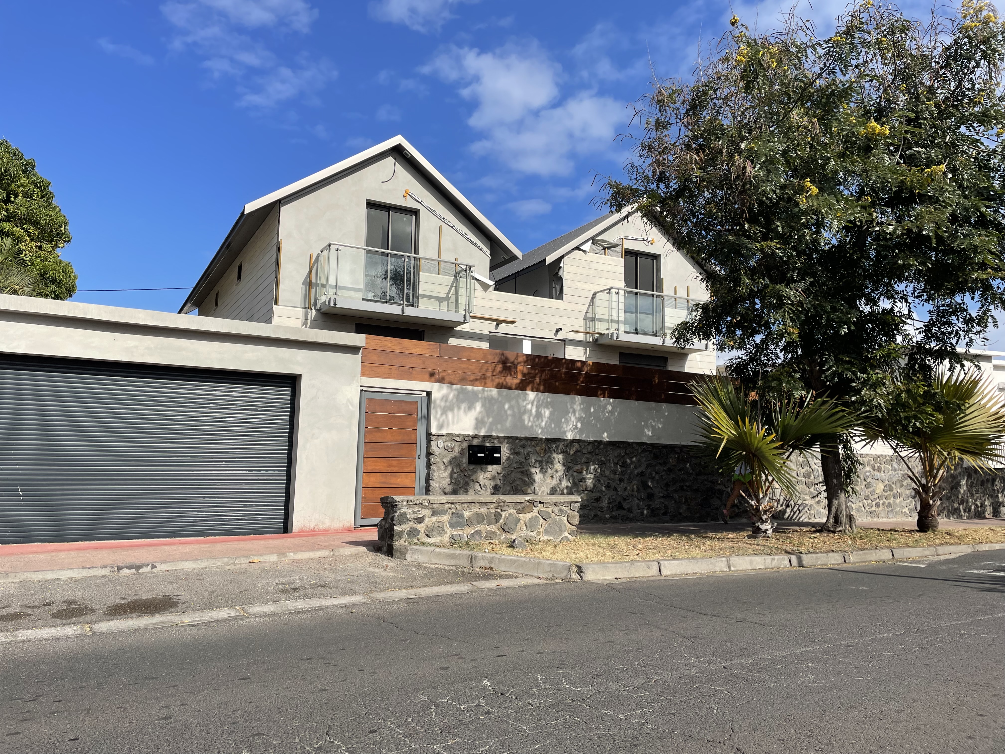 Maison individuelle avec façade en pierre basaltique et bardage bois à La Réunion